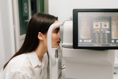 Girl undergoes an OCT eye exam using advanced optical coherence tomography equipment. The high-resolution display shows retinal scans, assisting in early diagnosis of eye diseases